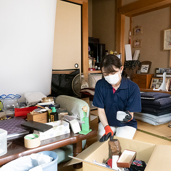 女性スタッフが遺品整理をしている