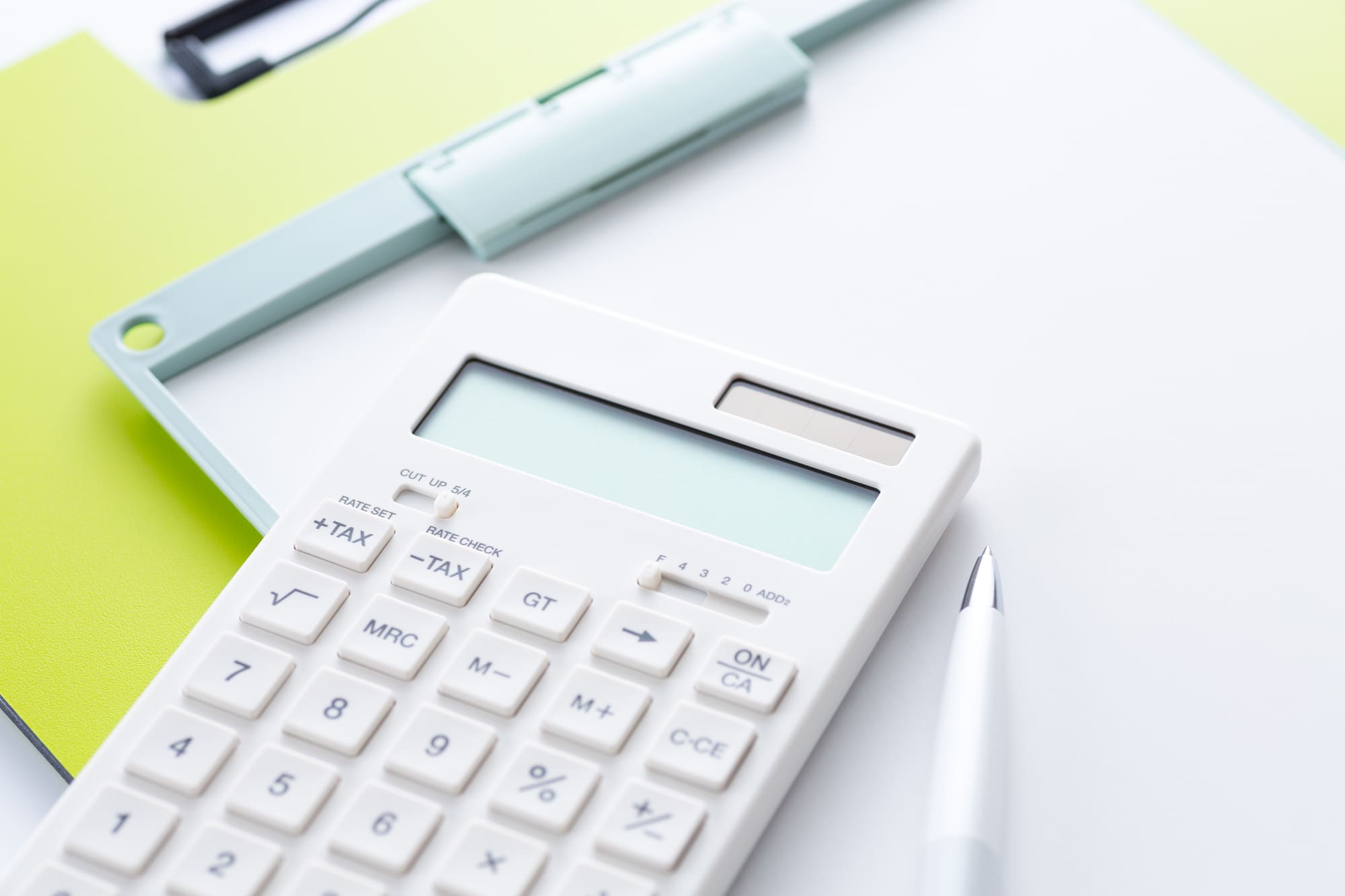 白い電卓とバインダーの写真